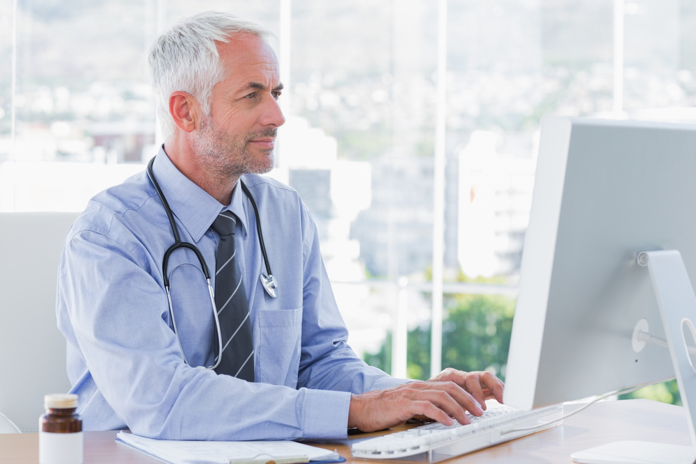 Doctor typing on his computer in the office